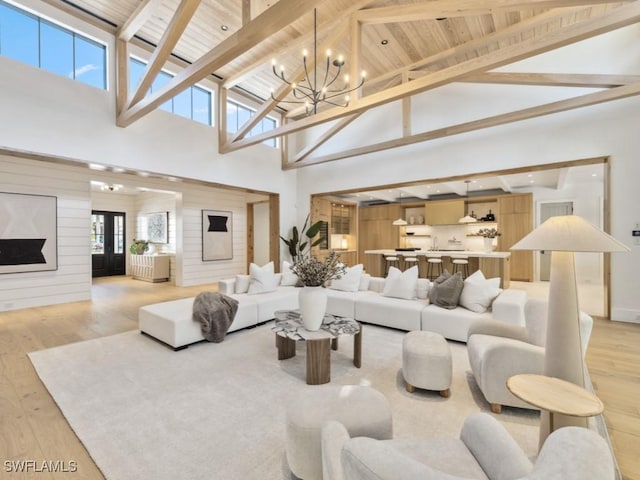 living room with a notable chandelier, wood ceiling, and light hardwood / wood-style flooring