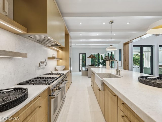 kitchen with range with two ovens, sink, pendant lighting, and light brown cabinets