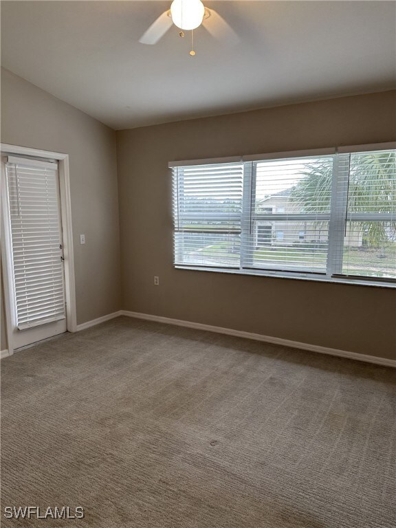 carpeted empty room featuring lofted ceiling and ceiling fan