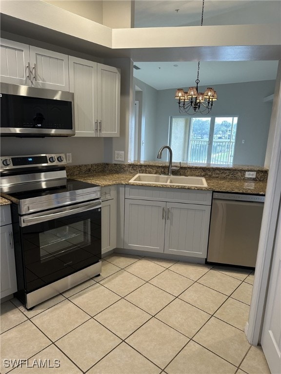 kitchen featuring sink, hanging light fixtures, light tile patterned floors, stainless steel appliances, and white cabinets