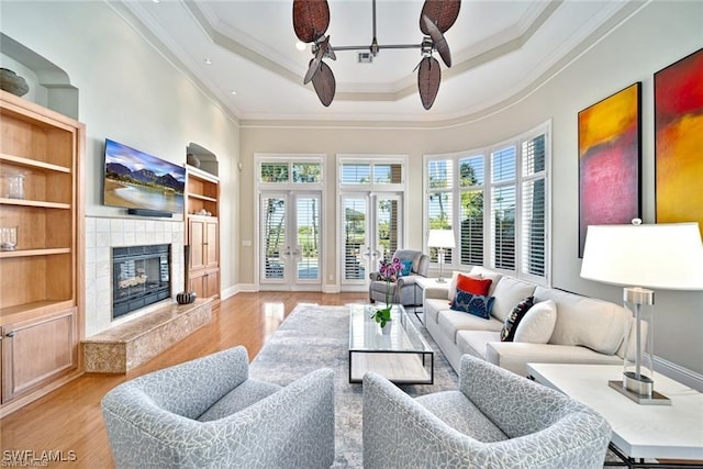 living room with french doors, a premium fireplace, a healthy amount of sunlight, and built in shelves