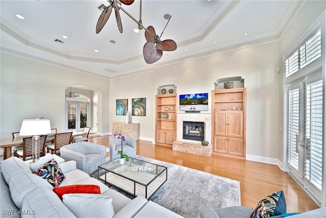 living room with crown molding, a tray ceiling, french doors, and ceiling fan