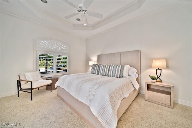 bedroom with a raised ceiling, crown molding, light colored carpet, and ceiling fan