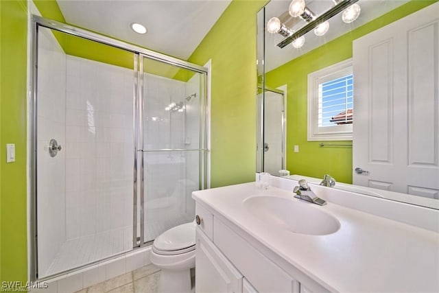 bathroom featuring tile patterned flooring, vanity, a shower with door, and toilet