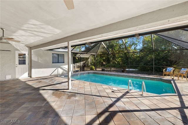 pool with glass enclosure, a ceiling fan, and a patio