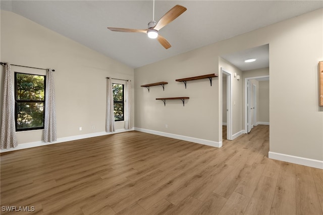 unfurnished living room with lofted ceiling, light wood-type flooring, a ceiling fan, and baseboards