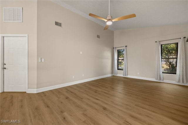 unfurnished room featuring light wood-type flooring, visible vents, and a healthy amount of sunlight