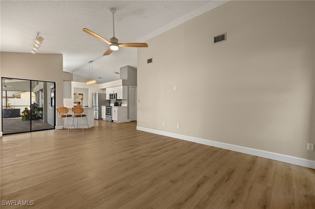 unfurnished living room featuring light wood finished floors, baseboards, visible vents, a ceiling fan, and high vaulted ceiling