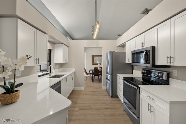 kitchen featuring a sink, visible vents, white cabinetry, appliances with stainless steel finishes, and pendant lighting