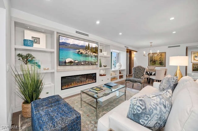 living room with an inviting chandelier and built in features