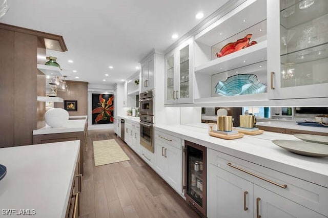 bar with hardwood / wood-style flooring, beverage cooler, double oven, and white cabinets