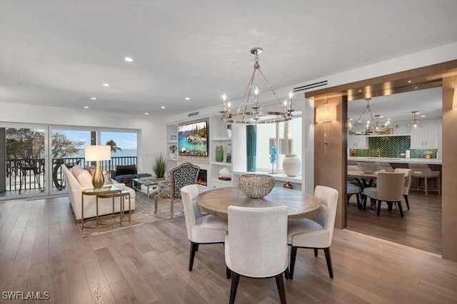 dining area with hardwood / wood-style flooring and an inviting chandelier