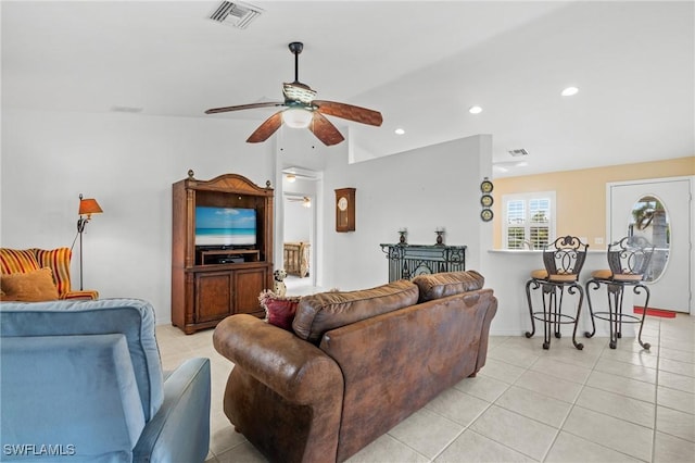 living room with lofted ceiling, ceiling fan, and light tile patterned floors