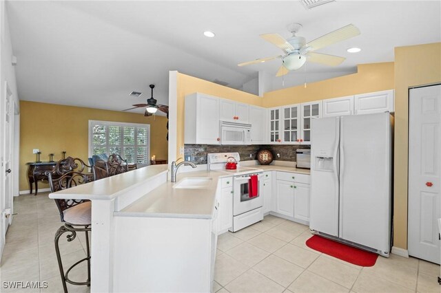 kitchen featuring sink, white appliances, kitchen peninsula, and white cabinets