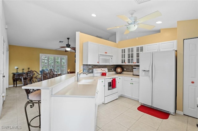 kitchen featuring white appliances, white cabinetry, sink, and kitchen peninsula