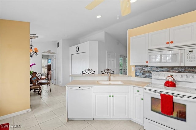 kitchen featuring white appliances, kitchen peninsula, sink, and white cabinets