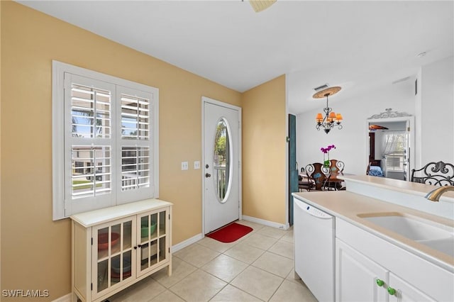 foyer featuring light tile patterned flooring, an inviting chandelier, and sink