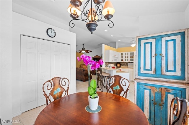 dining space with light tile patterned flooring, lofted ceiling, and a notable chandelier