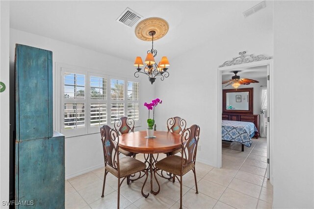 tiled dining room featuring a chandelier