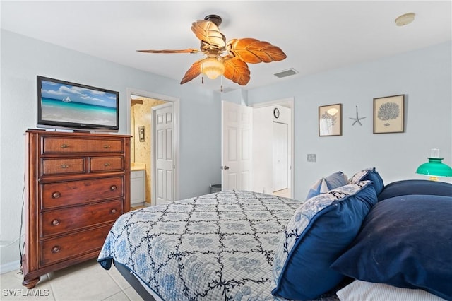 bedroom featuring ceiling fan, light tile patterned floors, and ensuite bath