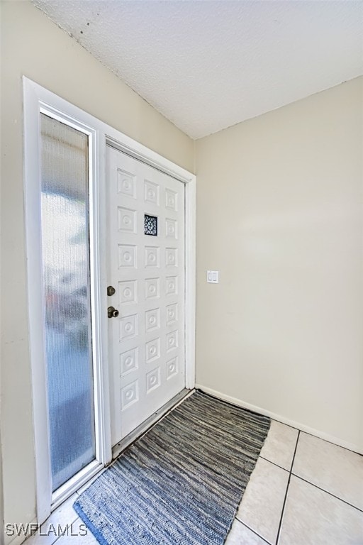 entrance foyer with tile patterned floors and a textured ceiling