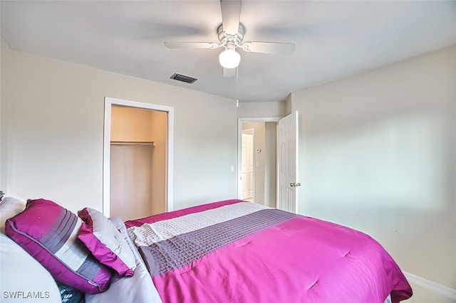 bedroom featuring a walk in closet, a closet, and ceiling fan