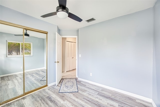 unfurnished bedroom featuring a closet, ceiling fan, and light wood-type flooring