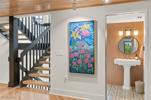 stairs featuring tile walls and hardwood / wood-style flooring