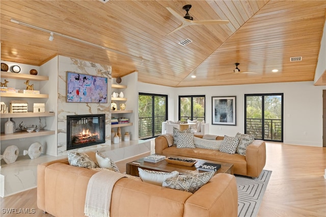 living room with ceiling fan, a premium fireplace, built in features, and wooden ceiling