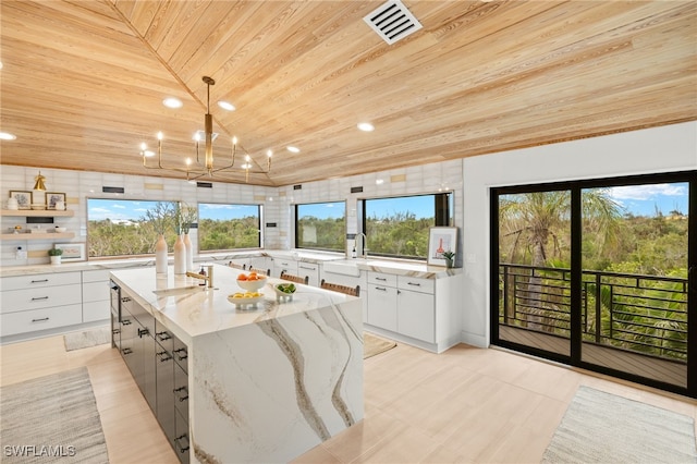 kitchen with a large island, wood ceiling, white cabinetry, hanging light fixtures, and light stone counters