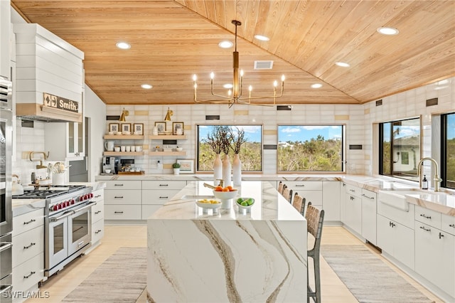 kitchen with decorative light fixtures, white cabinetry, sink, range with two ovens, and wood ceiling