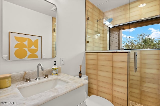 bathroom featuring vanity, toilet, and a shower with shower door