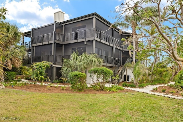 rear view of house featuring a lawn