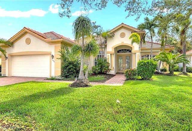 mediterranean / spanish home with a garage, a front yard, and french doors