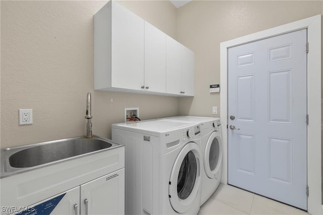 laundry room featuring independent washer and dryer, cabinets, sink, and light tile patterned floors