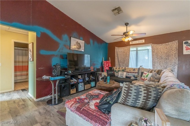 living room with ceiling fan, wood-type flooring, and vaulted ceiling