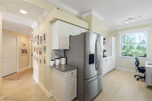 kitchen with crown molding, stainless steel fridge, white cabinetry, tasteful backsplash, and light hardwood / wood-style floors