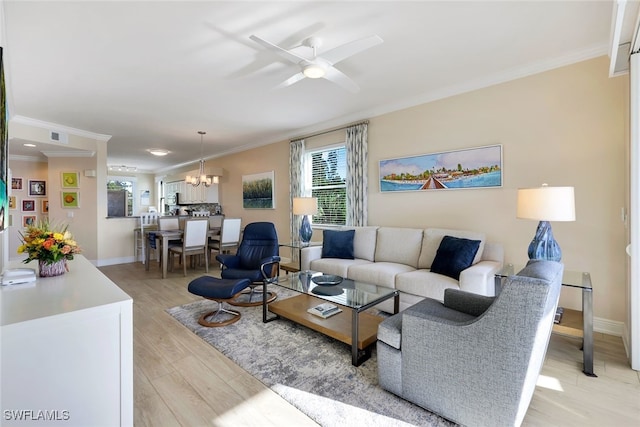 living room featuring crown molding, ceiling fan with notable chandelier, and light wood-type flooring