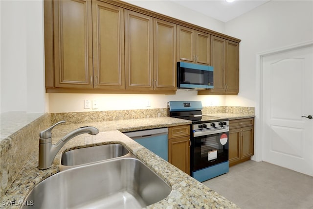 kitchen featuring appliances with stainless steel finishes, sink, light tile patterned floors, and light stone counters