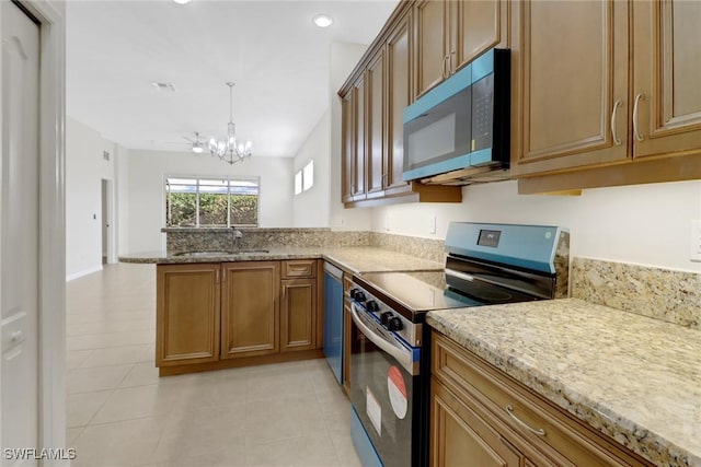 kitchen with light tile patterned flooring, appliances with stainless steel finishes, sink, and kitchen peninsula