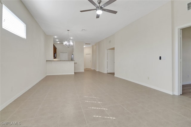 unfurnished living room with ceiling fan with notable chandelier and light tile patterned floors