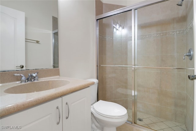 bathroom featuring vanity, toilet, and a shower with shower door