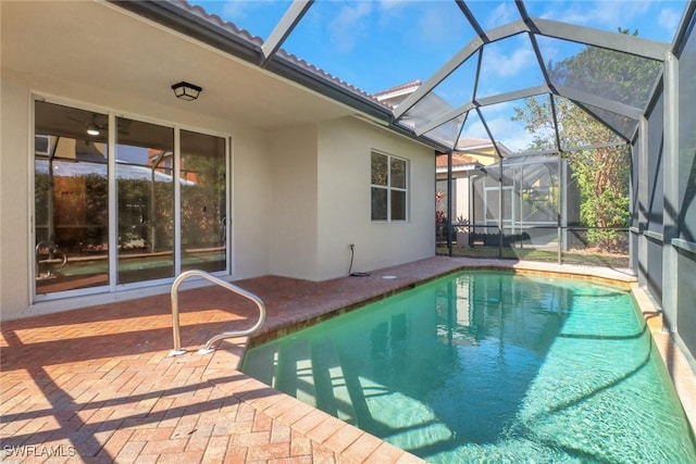 view of swimming pool featuring glass enclosure and a patio