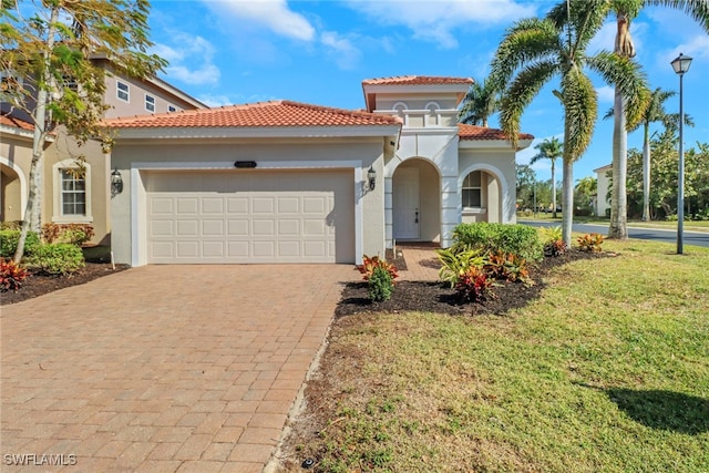 mediterranean / spanish house with a garage and a front lawn