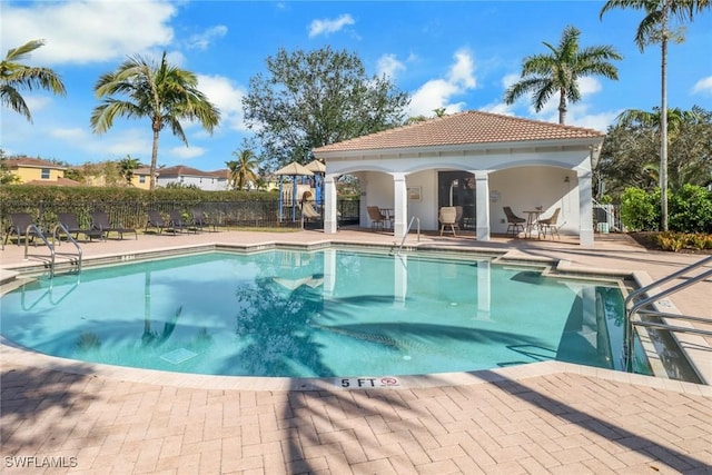 view of pool with an outbuilding and a patio area