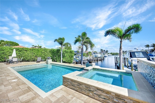 view of swimming pool with a water view, a boat dock, a pool with connected hot tub, boat lift, and a patio area