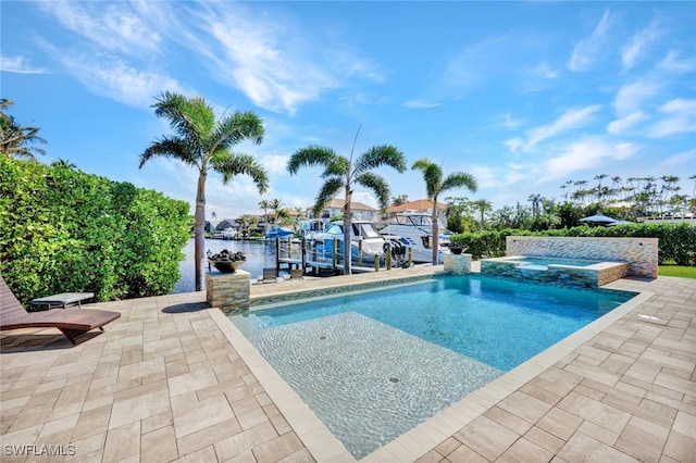 view of swimming pool with a patio area, a dock, a pool with connected hot tub, and boat lift