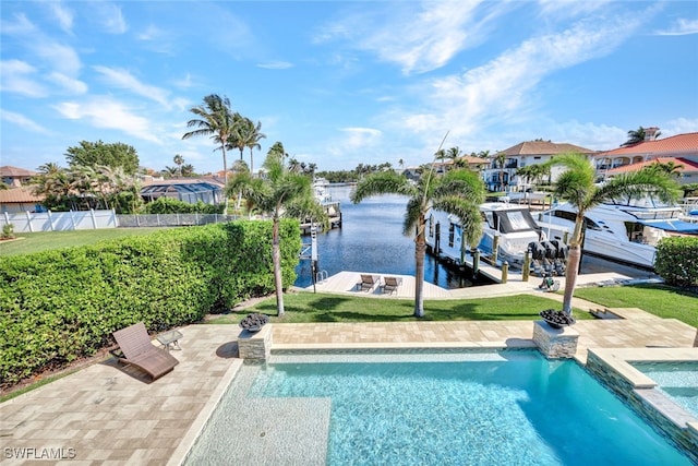 view of swimming pool with a yard, a water view, fence, and a patio area