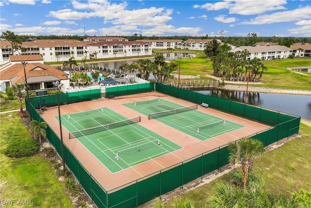 view of tennis court with a water view