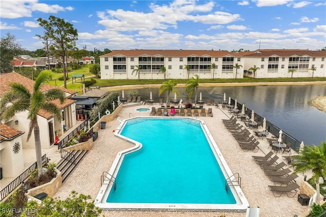 view of swimming pool with a water view and a patio area